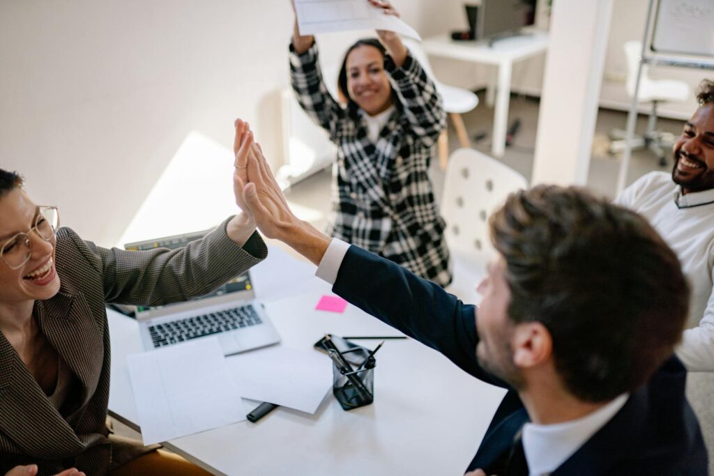 Business team exchanging a joyful high five in a modern office environment.