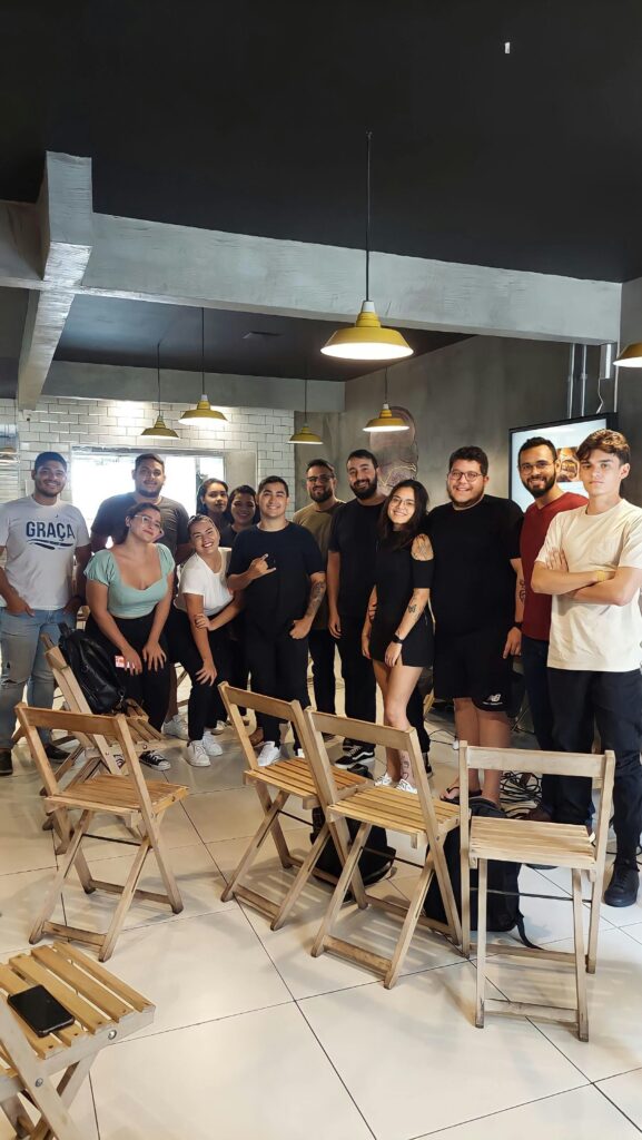 A diverse group of young adults gathered in a modern indoor setting, sharing a moment together.